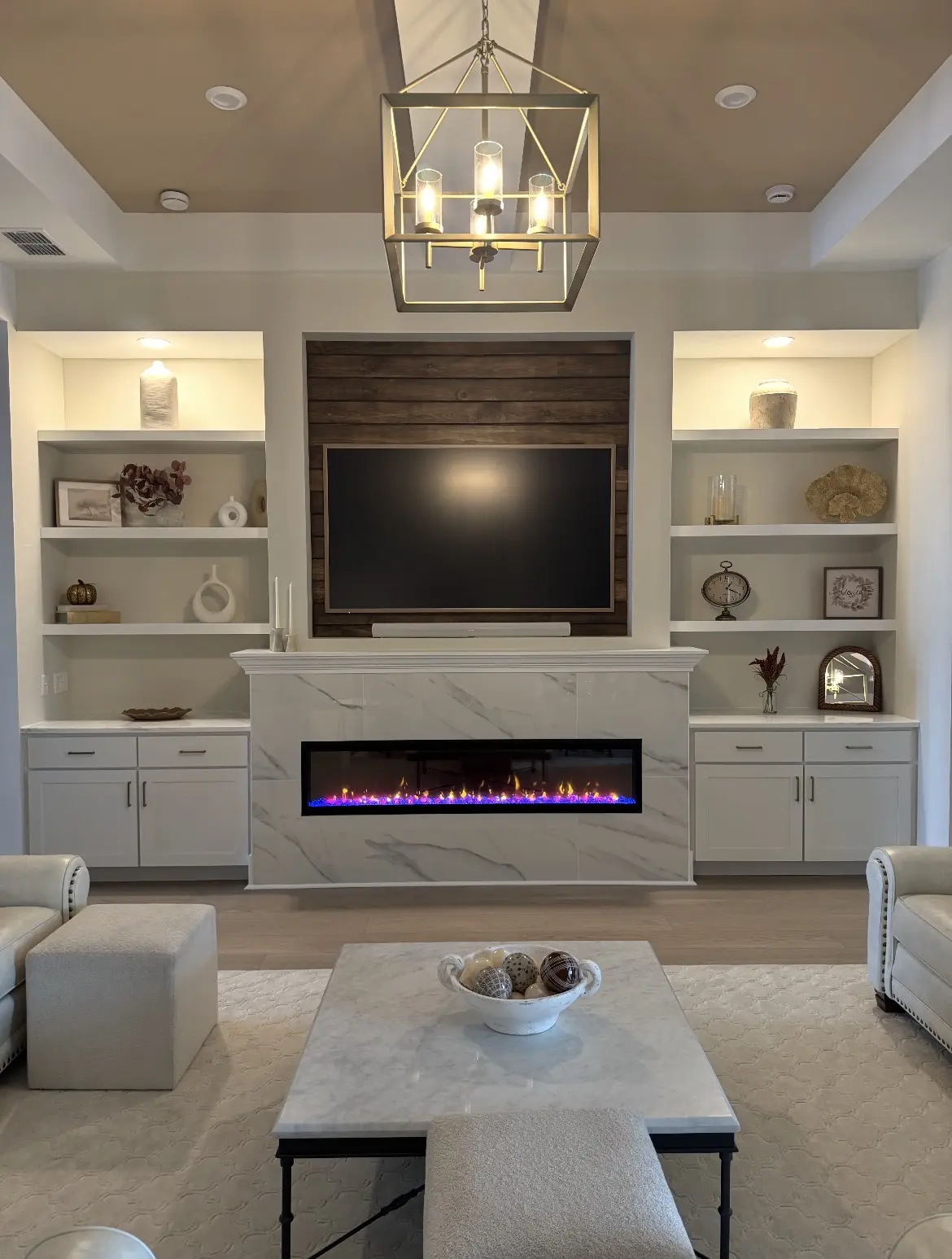 Remodeled living room with electric fireplace, television wall and illuminated built-in shelves